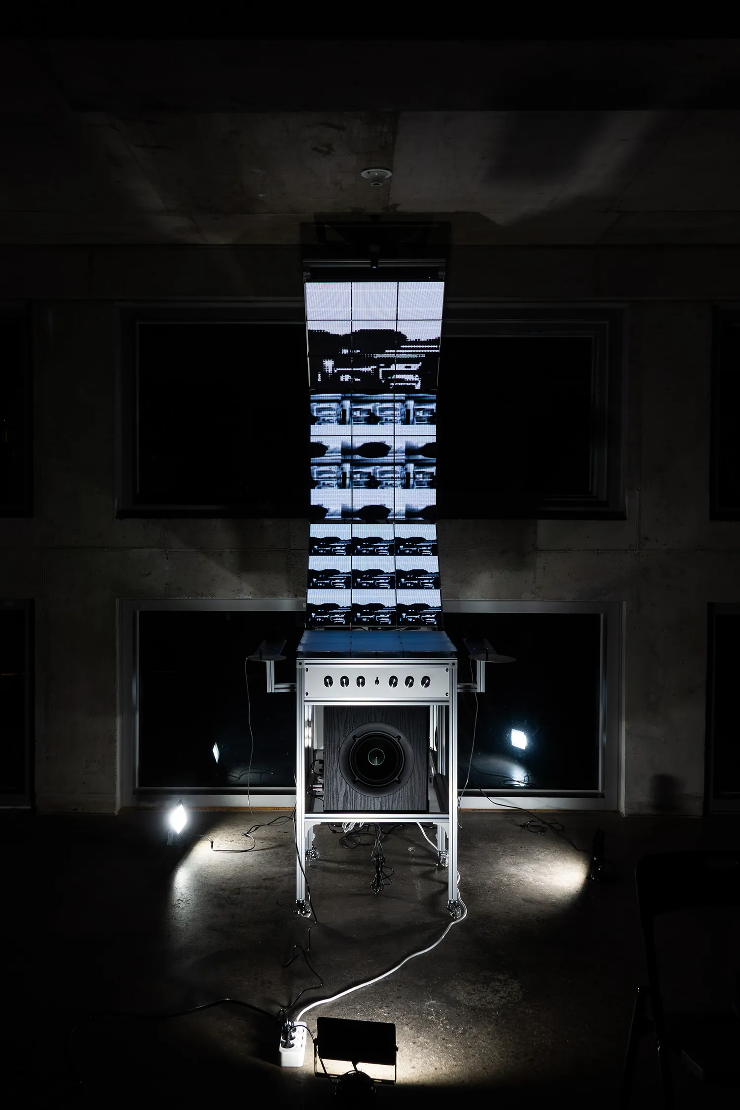Frontal view in the dark: the display stack reads as a single vertical column of light above the cabinet.